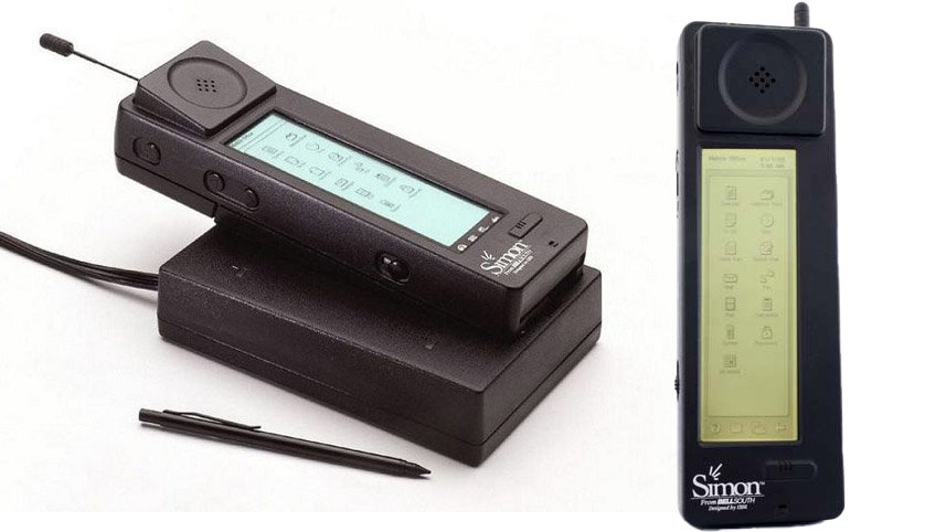 IBM Simon first smart phones image one is alone cell phone other one is sitting on cahrger and there is a pen to oprate its touch screen